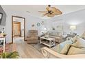 Living room featuring beachy decor, ceiling fan, a striped sofa, and recliner at 1502 Yaupon Dr. # A-1, Myrtle Beach, SC 29577