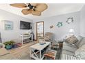Living room featuring beachy decor, ceiling fan, a striped sofa, and television at 1502 Yaupon Dr. # A-1, Myrtle Beach, SC 29577