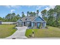 Charming blue two-story home with manicured lawn and lush trees in the background at 1509 Osage Dr., Myrtle Beach, SC 29579