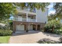 Charming home featuring a brick facade, a spacious driveway, and inviting multiple balconies at 1718 Perrin Dr., North Myrtle Beach, SC 29582