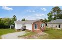 Attractive one-story house with brick accents, a metal roof, and a well-kept lawn at 175 Cypress Ln., Little River, SC 29566