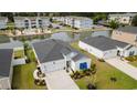 An aerial shot showcases a home with mature landscaping next to a community pond and pool creating a peaceful suburban setting at 179 S Reindeer Rd., Surfside Beach, SC 29575