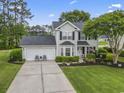 Attractive two-story home features an attached two-car garage, landscaping and is surrounded by mature trees at 216 Whitchurch St., Murrells Inlet, SC 29576