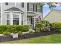 View of home's entryway featuring manicured landscaping, and a decorative American flag at 216 Whitchurch St., Murrells Inlet, SC 29576