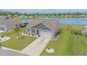 Aerial view of single-story home with lake view, well-maintained lawn, and community amenities at 227 Carmello Circle, Conway, SC 29526