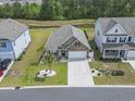 Aerial view of home with well-kept lawn, stone facade, close proximity to pond and neighboring homes at 239 Calhoun Falls Dr., Myrtle Beach, SC 29579