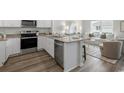 Open-concept kitchen with island seating, granite countertops, and modern appliances flows into living area at 332 Bayou Loop # Lot 69, Surfside Beach, SC 29575