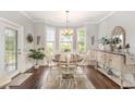 Bright dining room with a bay window, chandelier, hardwood floors, and stylish furniture at 349 N Bar Ct., Myrtle Beach, SC 29579