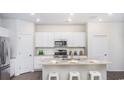 Modern kitchen featuring white cabinetry, stainless steel appliances, and a granite island with seating at 378 Ladyfish Loop, Sunset Beach, NC 28468