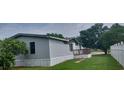 Exterior angle view of mobile home featuring light gray siding and a wooden porch with traditional railings at 3802 Stern Dr., Conway, SC 29526