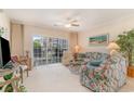 Cozy living room features a ceiling fan, comfortable seating and a sliding glass door to the outside at 4729 Wild Iris Dr. # 104, Myrtle Beach, SC 29577