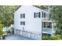 Side angle of a home with a three car garage, open patio, and second story porch at 486 Lantana Circle, Georgetown, SC 29440