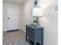 Inviting entryway featuring a stylish blue accent table with a lamp, complemented by light gray flooring and a white front door at 502 Sagebrush St., Myrtle Beach, SC 29588