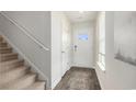 Bright entryway features wood-look floors, a staircase, and a white front door with glass, creating a welcoming ambiance at 512 Scarlet Sage Dr., Conway, SC 29527