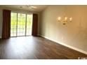 Open living area with a chandelier, wood floors, and sliding glass doors to the balcony at 5825 Catalina Dr. # 234, North Myrtle Beach, SC 29582