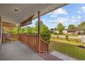 Cozy front porch with wooden railing and view of the landscaped yard at 706 Birch Ln., Conway, SC 29526