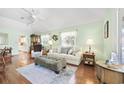 Cozy living room featuring hardwood floors, light green walls, comfortable seating, and abundant natural light at 820 9Th Ave. S, North Myrtle Beach, SC 29582