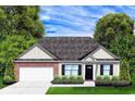 Charming single-story house boasts a manicured lawn, brick accents and a two-car garage at 962 Oak Hollow St., Longs, SC 29568