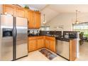 Kitchen with stainless steel appliances, wood cabinets, and granite countertops offers a functional and stylish space for cooking at 100 Birch N Coppice Dr. # 12, Surfside Beach, SC 29575