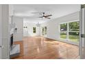 Spacious living room featuring large windows and beautiful hardwood floors, bathed in natural light, fireplace and ceiling fan at 1029 Old Plantation Dr., Pawleys Island, SC 29585
