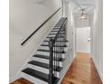 Elegant staircase with a black handrail and white risers, leading to the upper level of the home with hardwood floors at 1029 Old Plantation Dr., Pawleys Island, SC 29585
