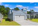 Stylish two-story home with blue siding, attached garage, and a well manicured lawn at 1055 Sentinel Ct., Little River, SC 29566