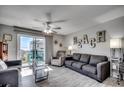 Living room with tile floors, beach decor, and a sliding glass door to a private balcony at 1208 S Ocean Blvd. # H, North Myrtle Beach, SC 29582