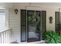 A cozy front porch featuring a decorative wreath, black shutters, and potted plants at 146 Stillwood Dr. # 3, Pawleys Island, SC 29585