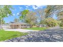 Quaint one-story home with a covered parking area, complemented by a lush green lawn and mature trees in the neighborhood at 1931 Jasper St., Georgetown, SC 29440