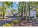 Exterior condo building with a landscaped yard featuring mature trees at 206 Pipers Ln. # 206, Myrtle Beach, SC 29575