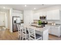 Bright kitchen with white cabinetry, stainless steel appliances, granite countertops, and an island with seating at 2112 Victory Way # 560, Myrtle Beach, SC 29579