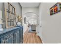Inviting hallway with an arched doorway, stylish decor, wood floors, and views into the living room at 240 Hillsborough Dr., Conway, SC 29526