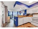 Open concept kitchen with modern white appliances, blue accents, and a view of the dining and living area at 2504 N Ocean Blvd. # 934, Myrtle Beach, SC 29577