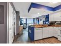 Bright, open kitchen featuring white appliances, blue accents, and seamless flow into the living and dining space at 2504 N Ocean Blvd. # 934, Myrtle Beach, SC 29577