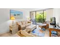 Comfortable living room with wicker furnishings, beach-themed art, and sliding glass doors to an outdoor balcony at 311 71St Ave. N # 3-D, Myrtle Beach, SC 29572