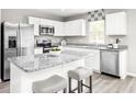 Modern kitchen with stainless steel appliances, granite counters, and an island with bar seating at 3208 Nw Edgemead Circle # B, Calabash, NC 28467