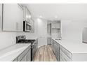 Bright kitchen with stainless steel appliances, gray cabinets, quartz countertops and wood flooring at 3332 Little Bay Dr., Conway, SC 29526