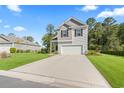 Well-manicured lawn complements this home featuring a two-car garage and a classic design with gray accents at 4005 Sweetspire Court, Conway, SC 29526
