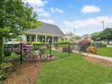 Charming home featuring a well-kept lawn, black fence, and mature landscaping, offering curb appeal at 407 15Th Ave. S, North Myrtle Beach, SC 29582