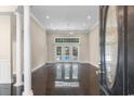 Bright living room featuring elegant columns, tile flooring, and double doors leading to the backyard pool at 4084 Hagwood Circle, Conway, SC 29526