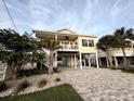 Elevated coastal home with a covered porch, tropical landscaping, and a spacious paved driveway at 412 29Th Ave. N, North Myrtle Beach, SC 29582