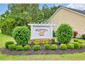 Welcoming sign for Rivertown Row, surrounded by manicured bushes and lush landscaping at 4200 Woodcliffe Dr., Conway, SC 29526