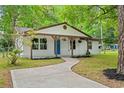 Attractive exterior view with a concrete walkway leading to the delightful blue front door and covered porch at 421 Villa Woods Dr., Myrtle Beach, SC 29579