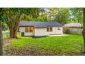 Rear of the property with a well-maintained yard, black roof and neutral trim at 421 Villa Woods Dr., Myrtle Beach, SC 29579