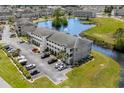 Aerial view of the condo building with pond view, parking and lush green landscaping surrounding the property at 4503 W Harbour Ct. # S9, Little River, SC 29566