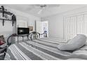 Comfortable bedroom with a striped comforter, ceiling fan, dresser, and access to a bathroom at 4616 Greenbriar Dr. # H-4, Little River, SC 29566