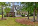 Beautiful home exterior with brick accents, a covered porch, and mature trees at 4721 National Dr., Myrtle Beach, SC 29579