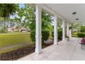 Inviting covered front porch with tiled floor, white columns, and views of the landscaped yard at 4721 National Dr., Myrtle Beach, SC 29579