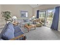 This is a shot of a well-lit living room with couches, tables, and a sliding door leading to the outside at 4878 Luster Leaf Circle # 402, Myrtle Beach, SC 29577