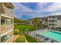 Community pool and lawn area surrounded by condo buildings, offering a relaxing outdoor space at 5601 N Ocean Blvd. # A-206, Myrtle Beach, SC 29577